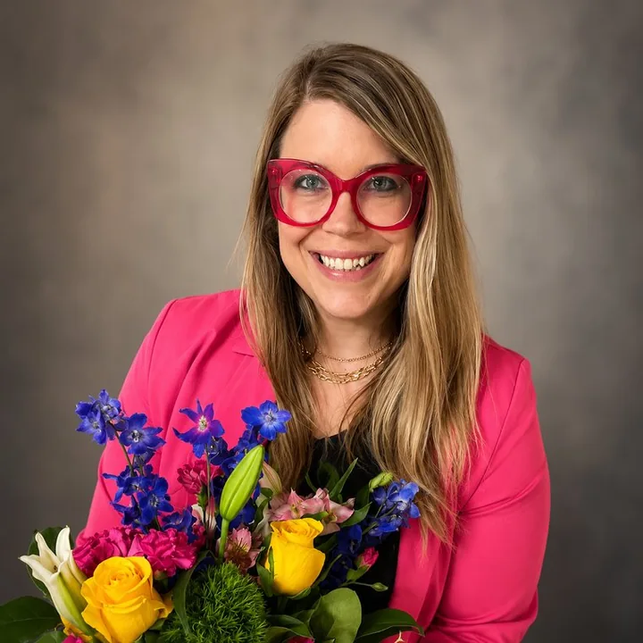 Mariah Gibson, smiling, holding a bouquet of bright flowers